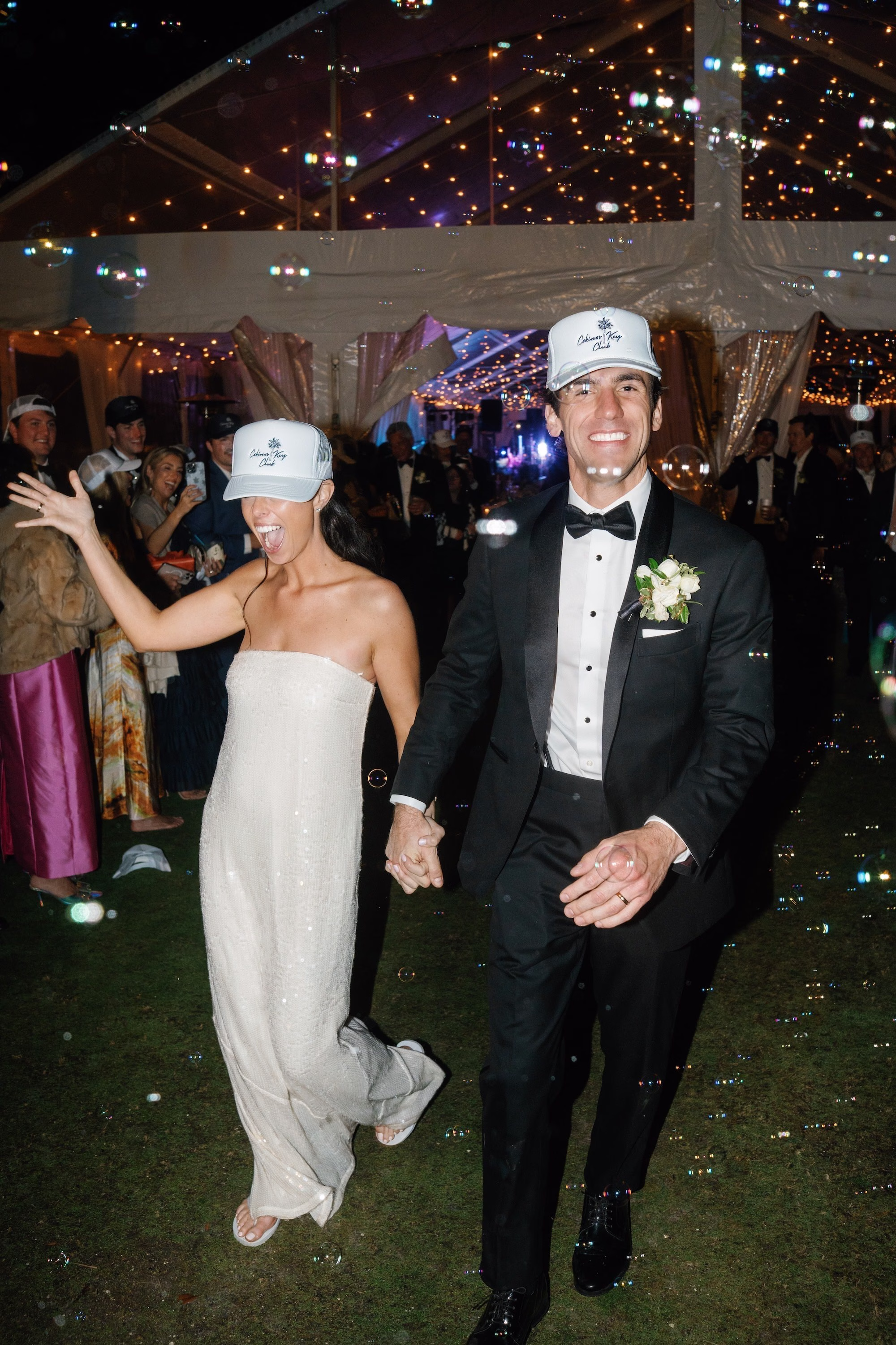 39Coastal Nancy Meyers Inspired Florida Beach Wedding - Coastal Blue, White, and Green Sarasota Wedding | The Resort at Longboat Key Club Bride in White Sequin Reception Dress and Groom in Custom Trucker Hats Wedding Bubble Exit Under Clear Tent