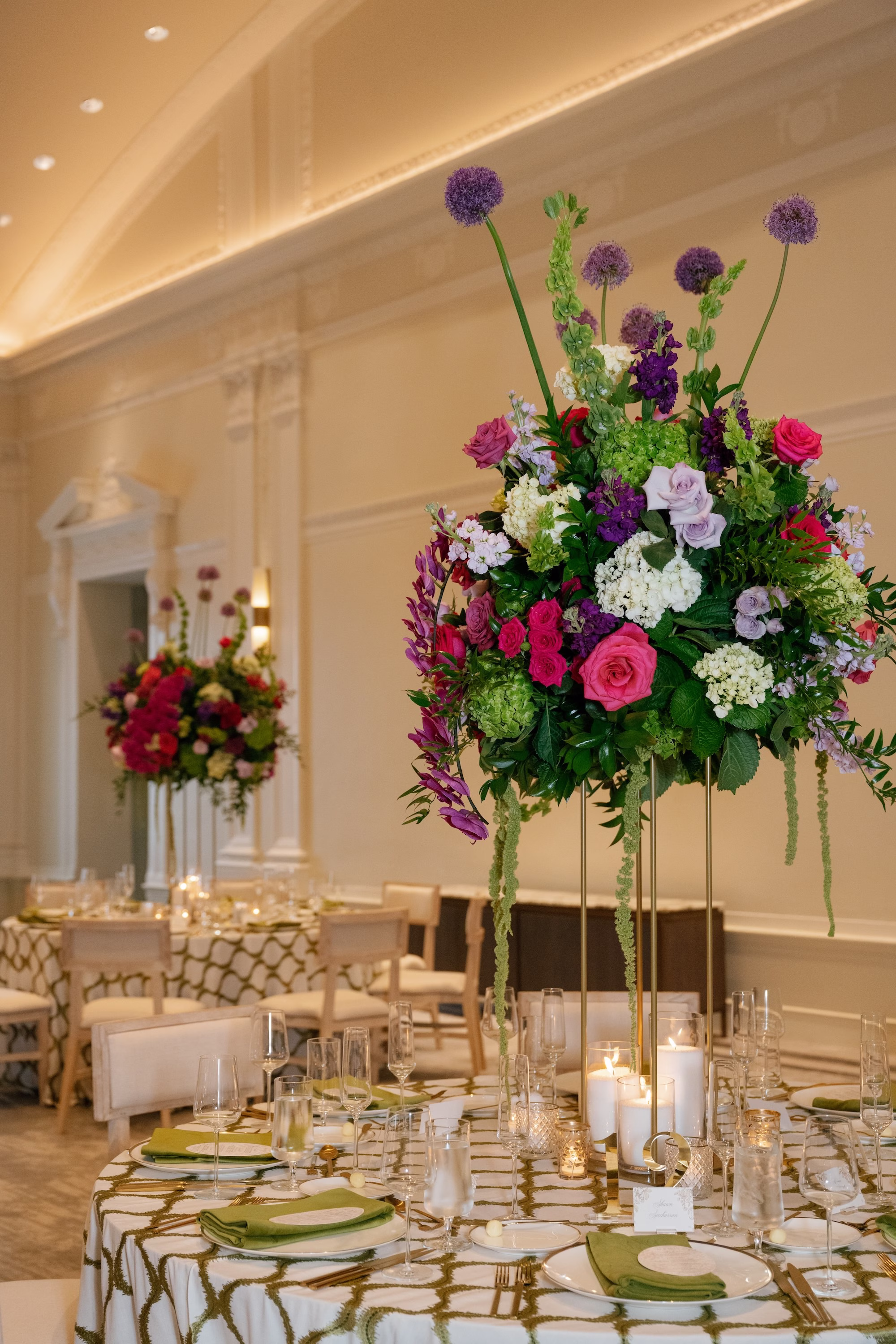 Tall Gold Stand Centerpiece with Vibrant Fuchsia, Purple, Red and Green Roses, Allium, Hydrangea and Hanging Amaranthus on Green Geometric Linen Wedding Reception Ideas | St. Pete Florist Bruce Wayne Florals