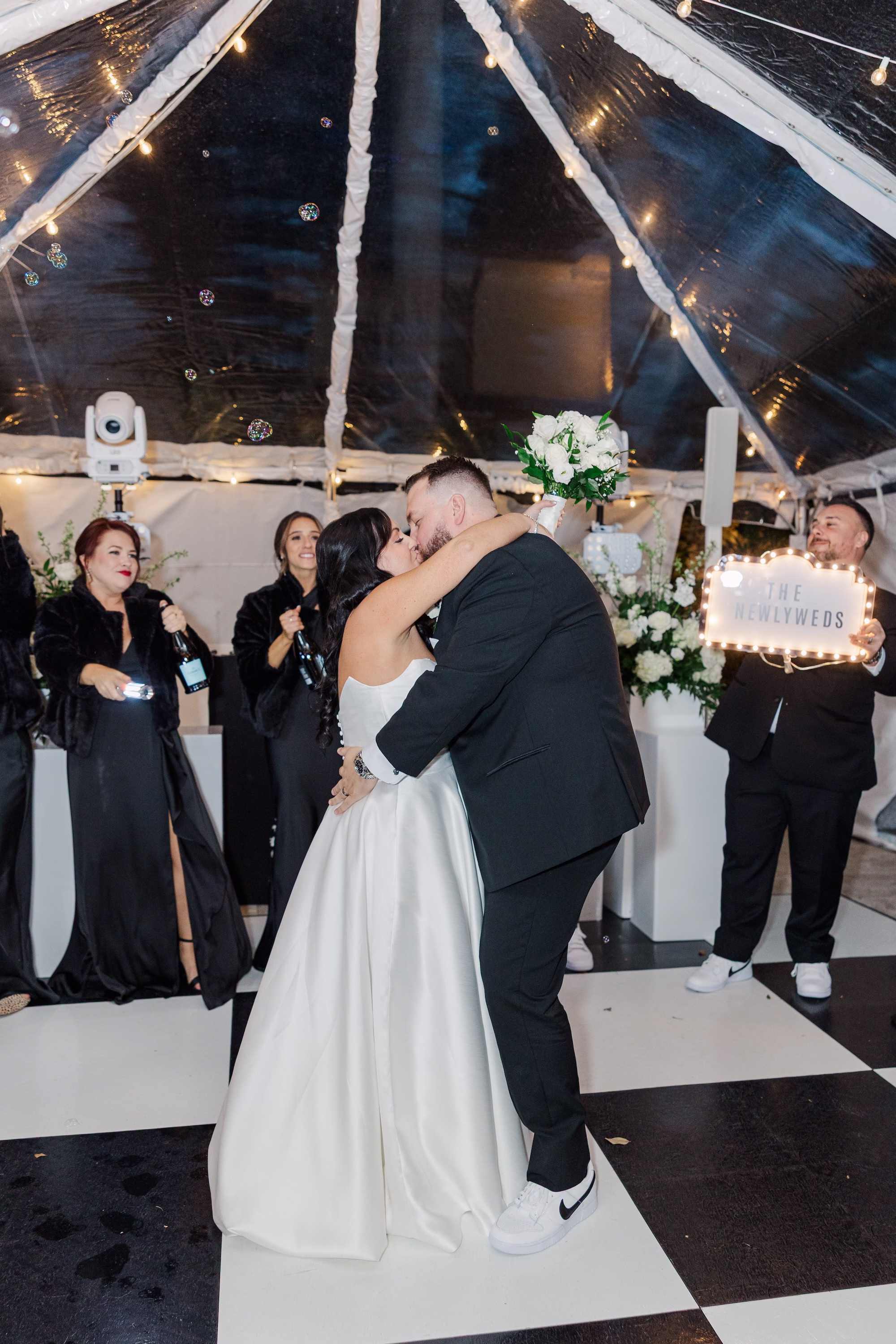Bride and Groom First Dance Wedding Portrait on Black and White Checkered Dance Floor Under Clear Tent | Palmetto Rentals Kate Ryan Event Rentals | DJ Graingertainment | Content Creator Behind the Vows