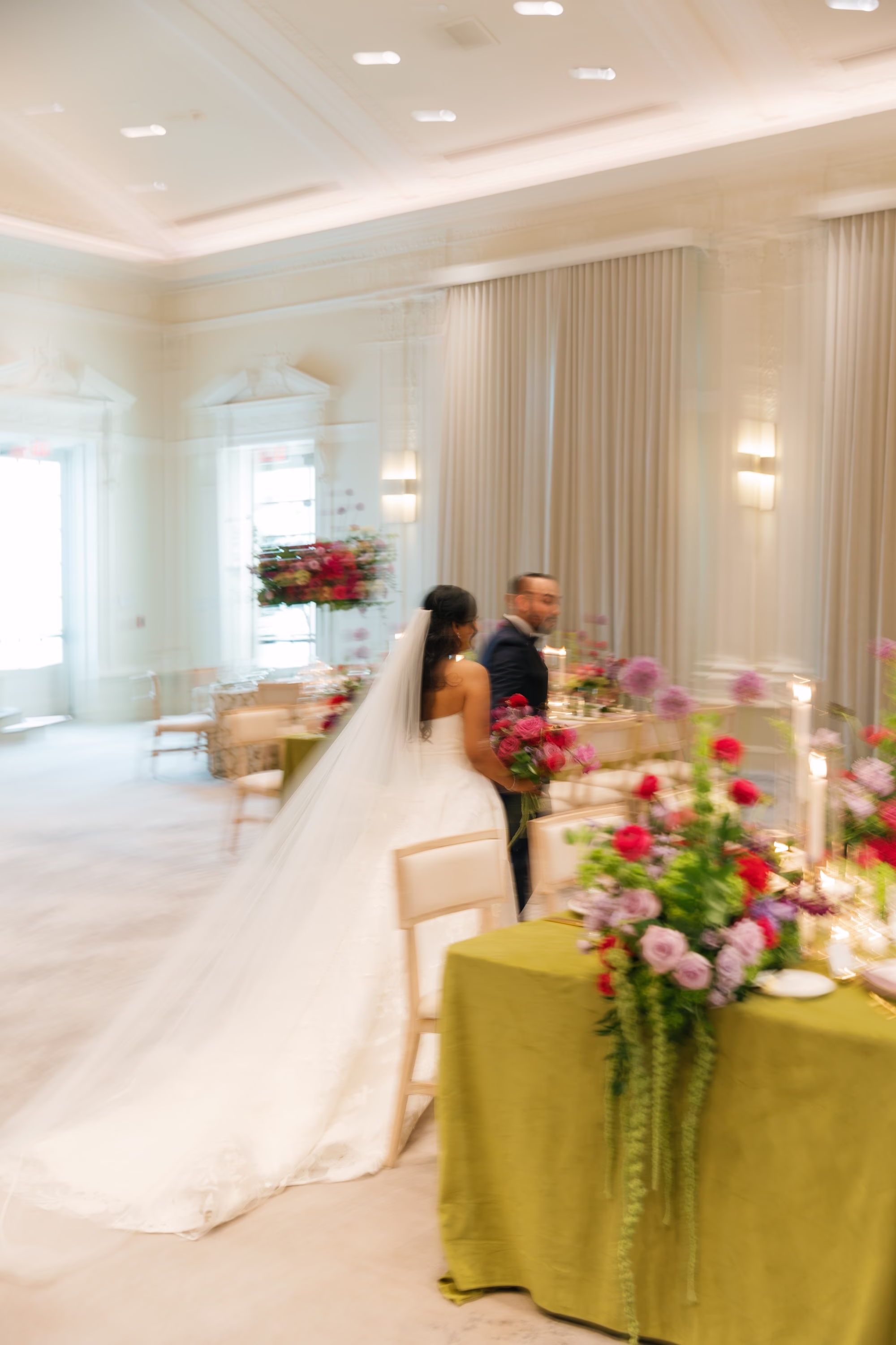 Bride and Groom Standing at Green Velvet Sweetheart Table with Vibrant Pink Floral Arrangements Wedding Reception Portrait | St. Pete Florist Bruce Wayne Florals