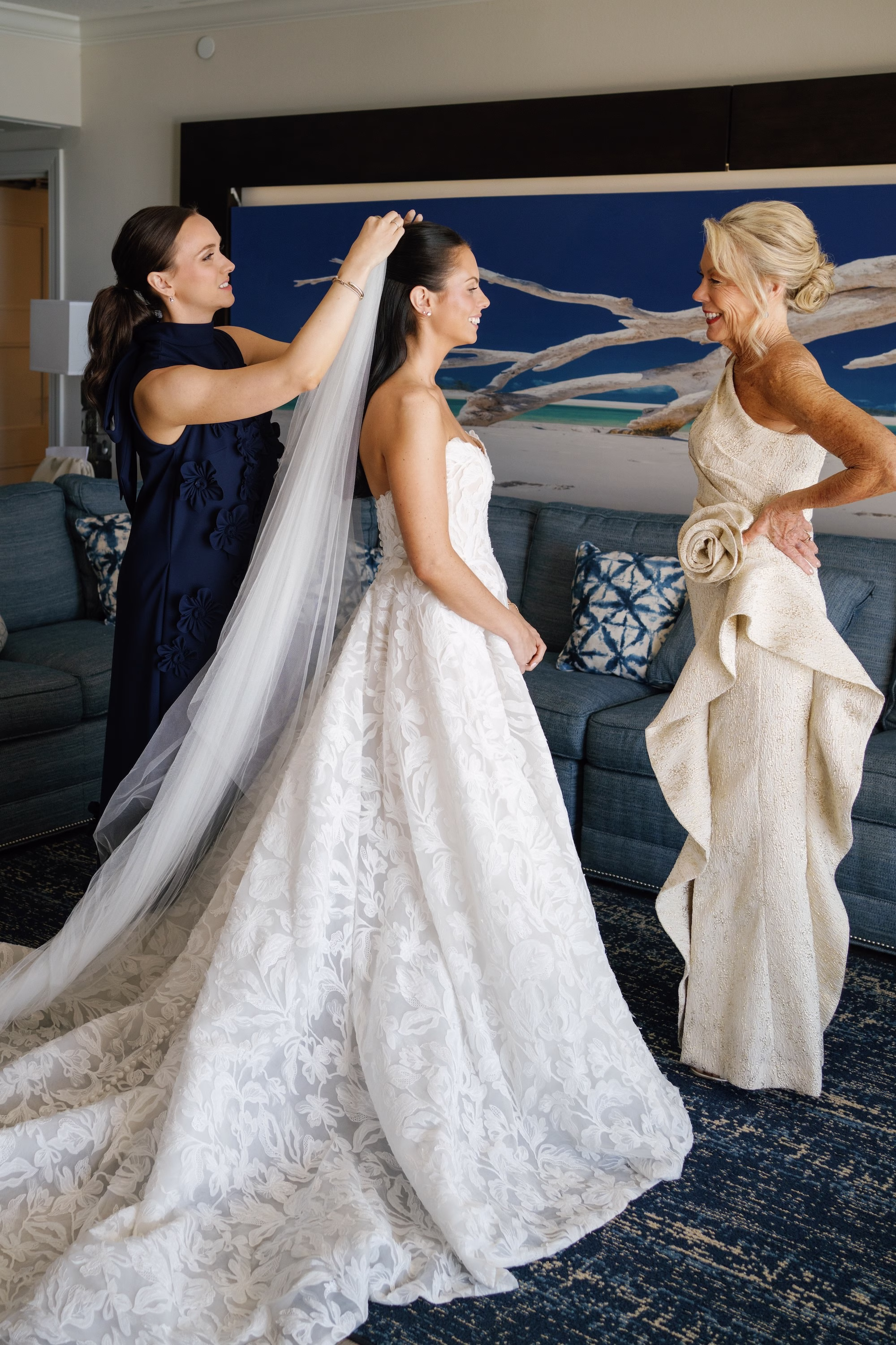 5Coastal Nancy Meyers Inspired Florida Beach Wedding - Coastal Blue, White, and Green Sarasota Wedding | The Resort at Longboat Key Club Mother and Sister Placing Cathedral Veil on Bride in Ivory Floral Lace Jenny Yoo Ballgown Getting Ready Portrait