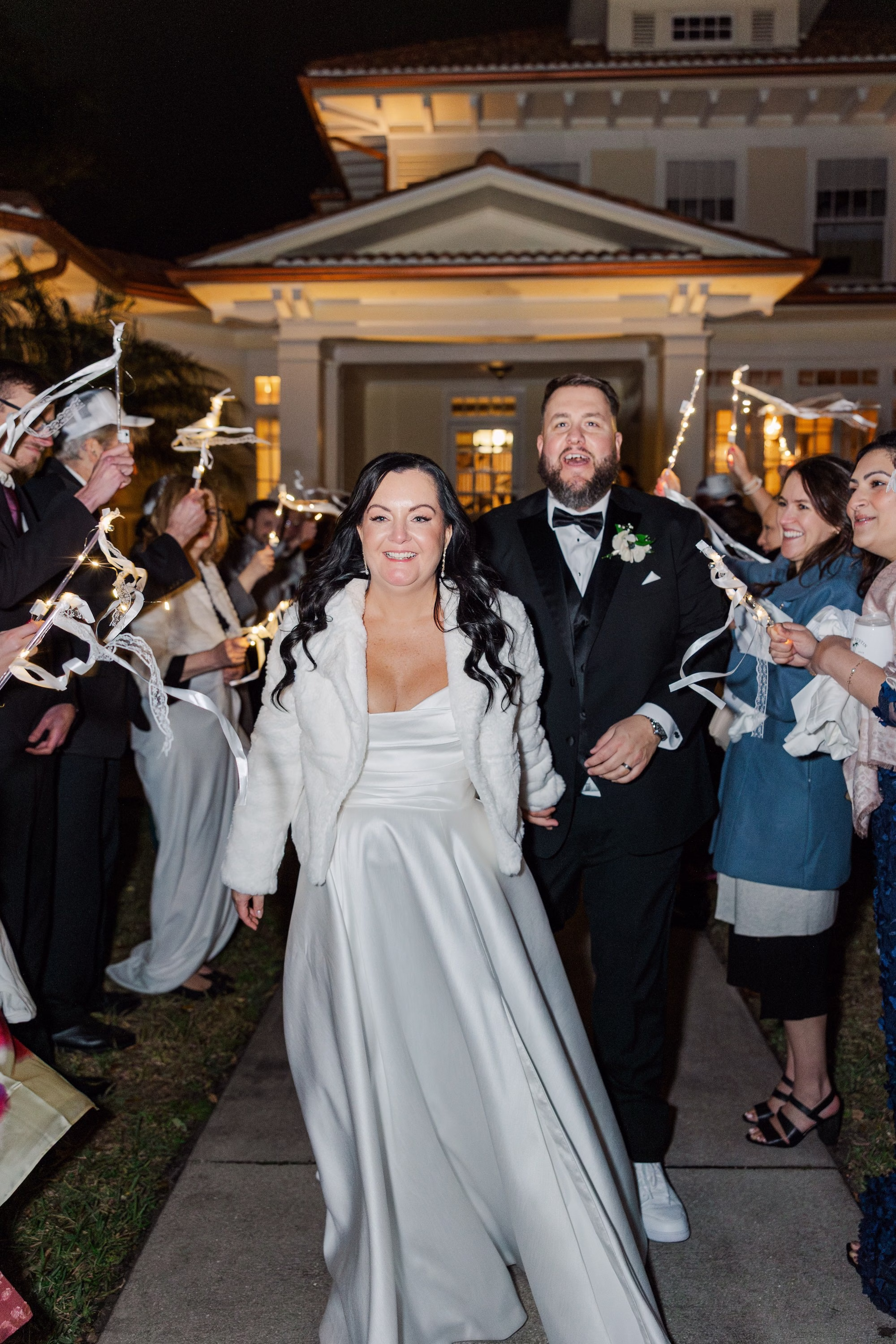 Bride and Groom Wedding Exit with Guests Waving Light Up Ribbon Wands Outside Old Florida Home