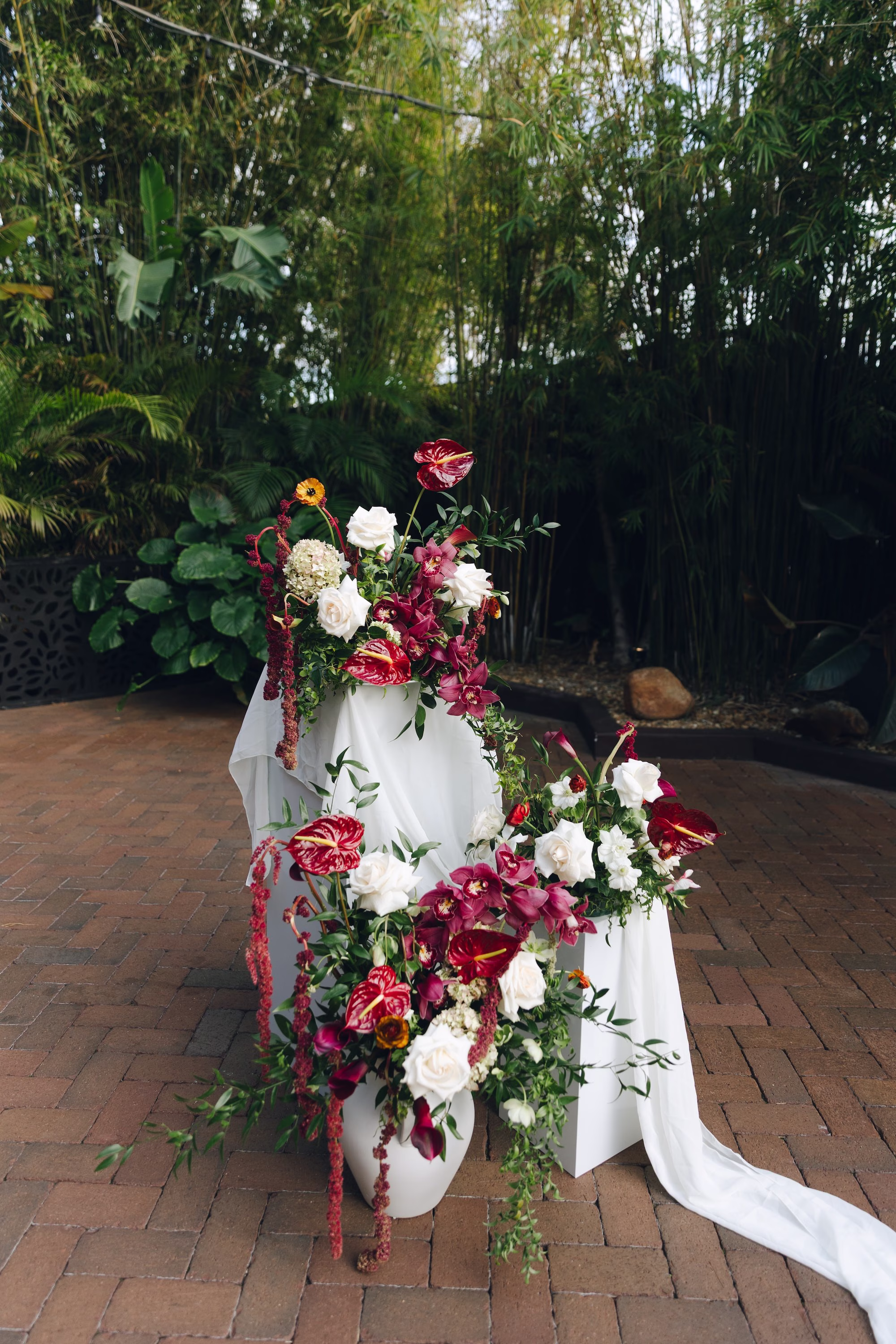 12Burgundy Vintage Romance Wedding Ideas - Vintage Romance Pink and Burgundy Downtown St. Pete Wedding | NOVA 535 White Pedestal Ceremony Arrangement with Burgundy Anthurium, Orchids and White Roses with Flowing White Fabric Ideas