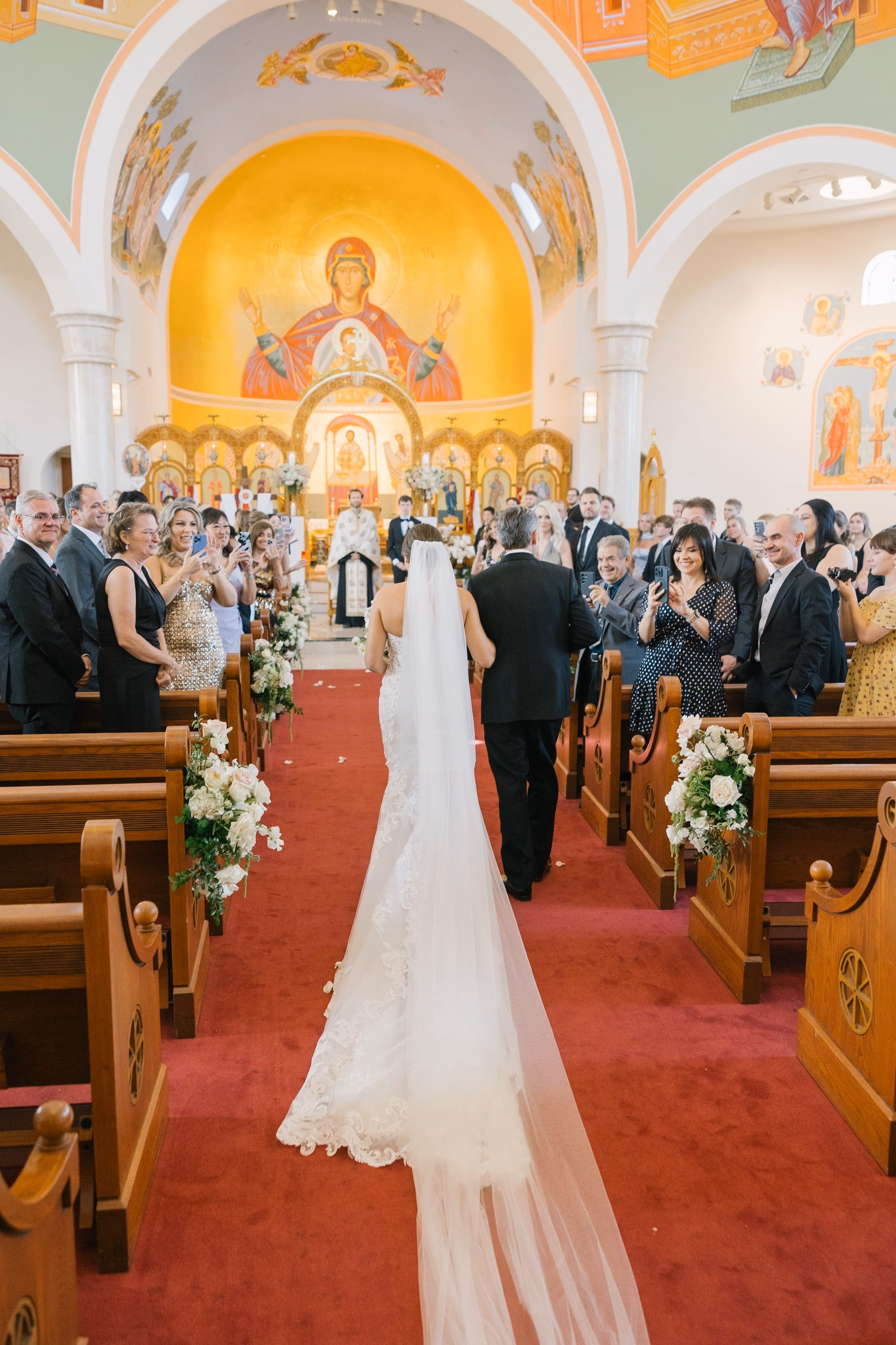 12Luxurious Romantic Garden Ballroom Wedding Inspiration Naples VenueSt. Katherines Greek - Luxurious Garden-Inspired Naples Wedding | Hyatt Regency Coconut Point Bride and Father Walking Down Wedding Ceremony Aisle | Traditional Greek Orthodox Wedding Ceremony Inspiration | Gold Iconography and White Floral Altar Decor Ideas | Bonita Springs Venue St. Katherine Greek Orthodox Church
