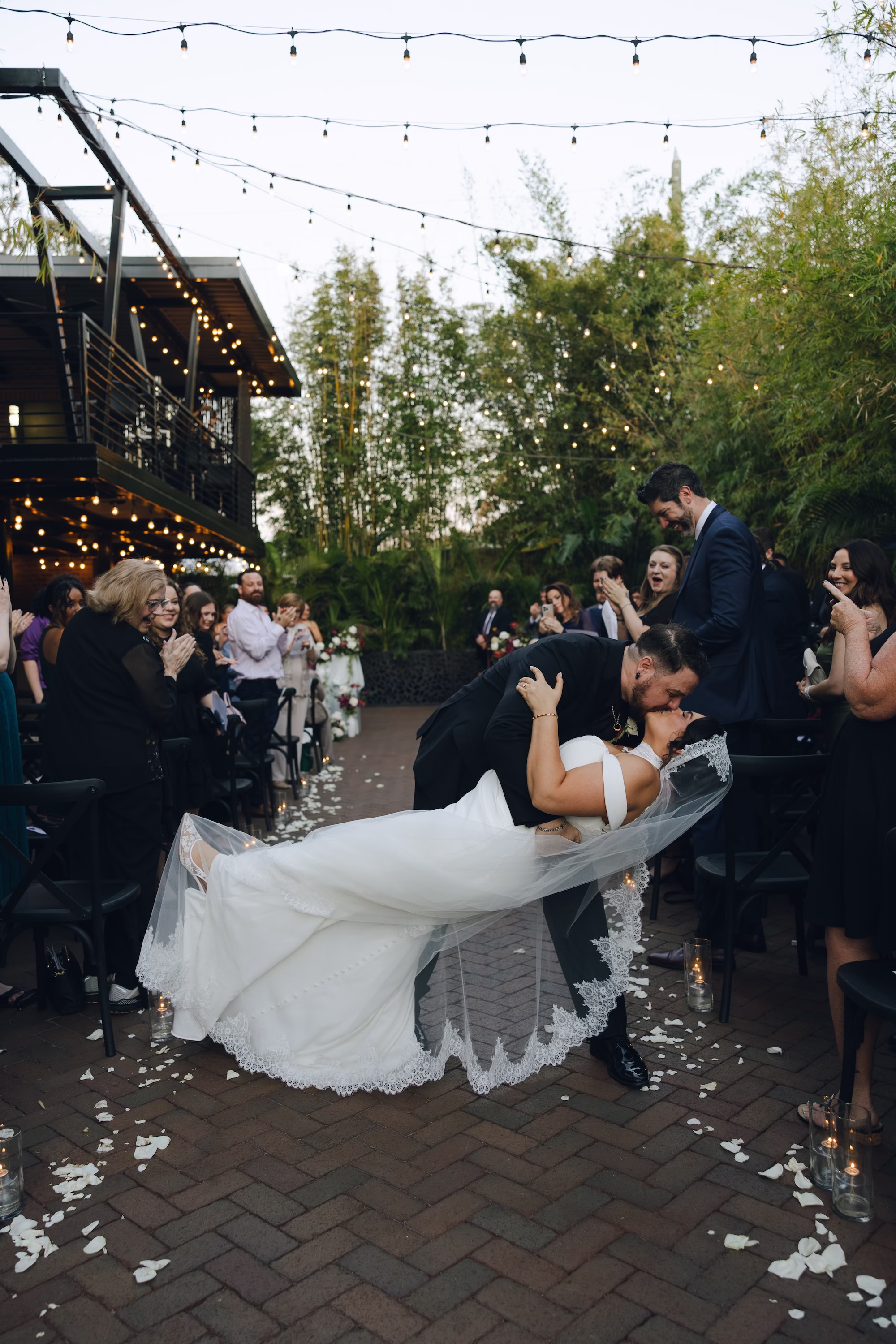 20Burgundy Vintage Romance Wedding Ideas - Vintage Romance Pink and Burgundy Downtown St. Pete Wedding | NOVA 535 Groom Dipping Bride for First Kiss Down the Petal-Lined Aisle with Guests Cheering