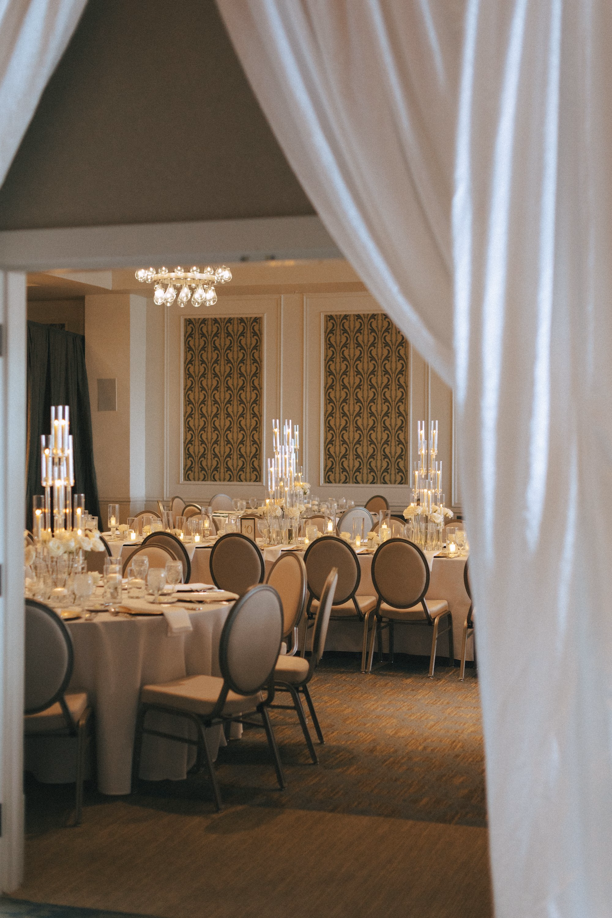 Ballroom Wedding Reception with White Draping, Round Tables, Oval Back Chairs and Tall Candle Centerpieces Decor Ideas | St. Pete Venue The Birchwood