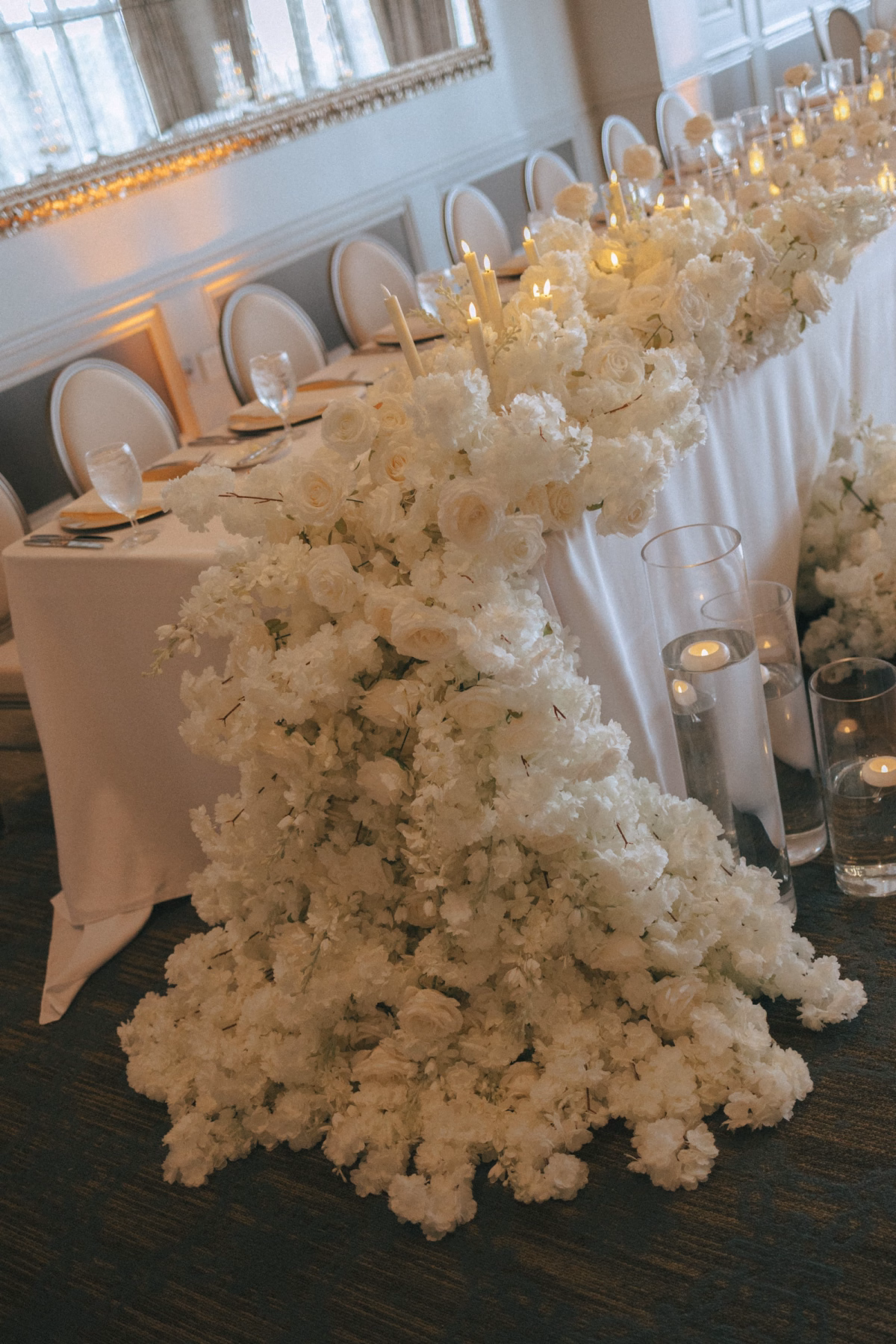 Cascading White Rose and Hydrangea Floral Runner on Long Wedding Reception Table with Taper Candles Decor Ideas