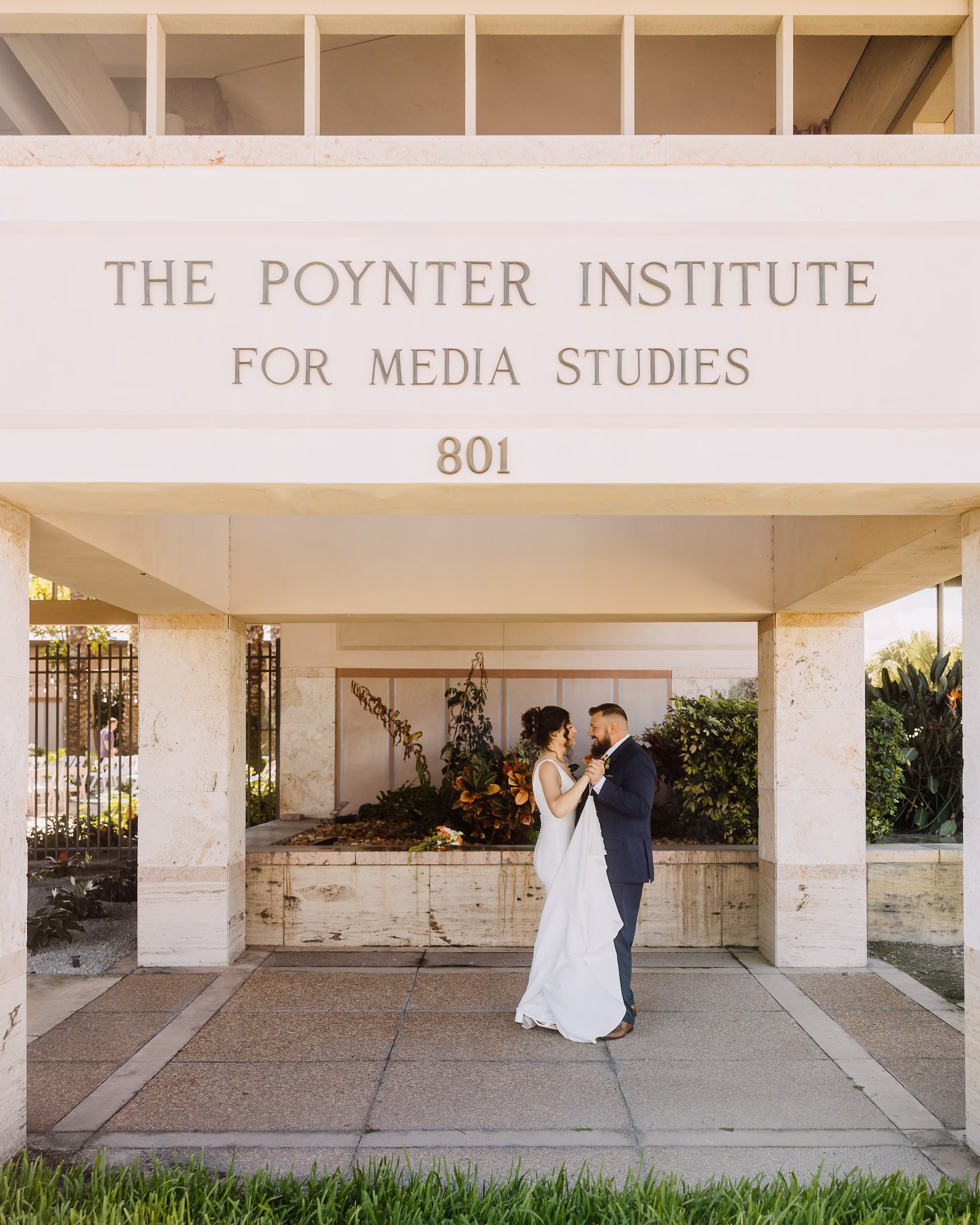 Bride and Groom Portrait Under Venue Entrance Sign | St. Pete Venue The Poynter Institute