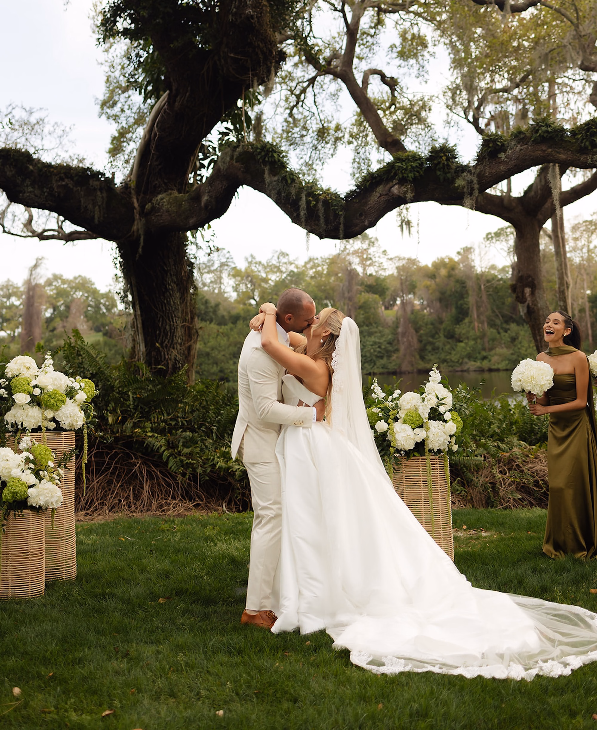 Bride and Groom First Kiss Under Live Oak Tree with White Hydrangea Arrangements at Lakeside Ceremony | Lakeside Lawn Wedding Ceremony at Palm Harbor Venue Innisbrook Golf & Spa Resort