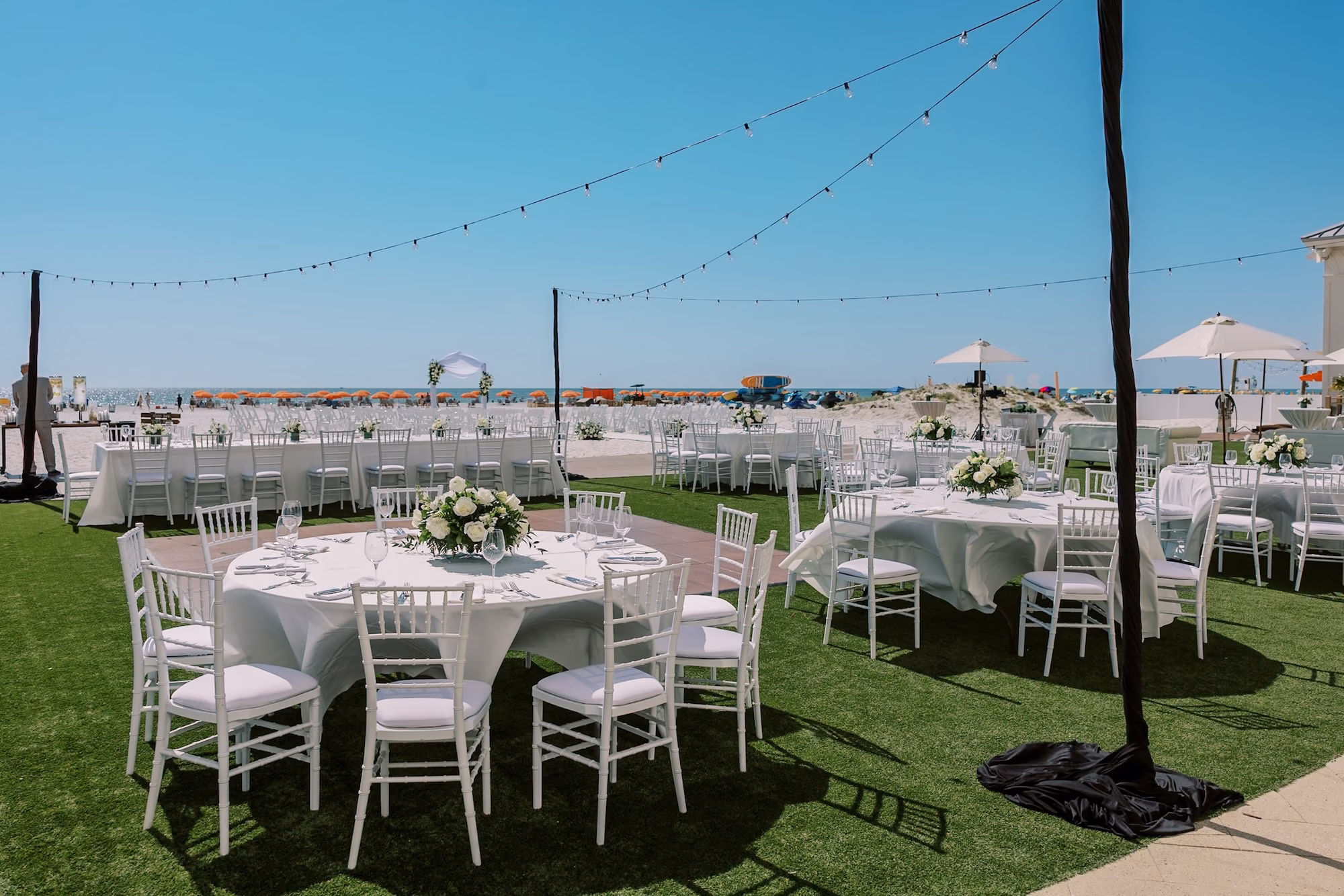 Outdoor Lawn Wedding Reception Overlooking the Gulf with White Chiavari Chairs, White Linens and String Lights Decor Ideas | Clearwater Beach Venue Sandpearl Resort | Planner Special Moments Event Planning | Rentals Gabro Event Services
