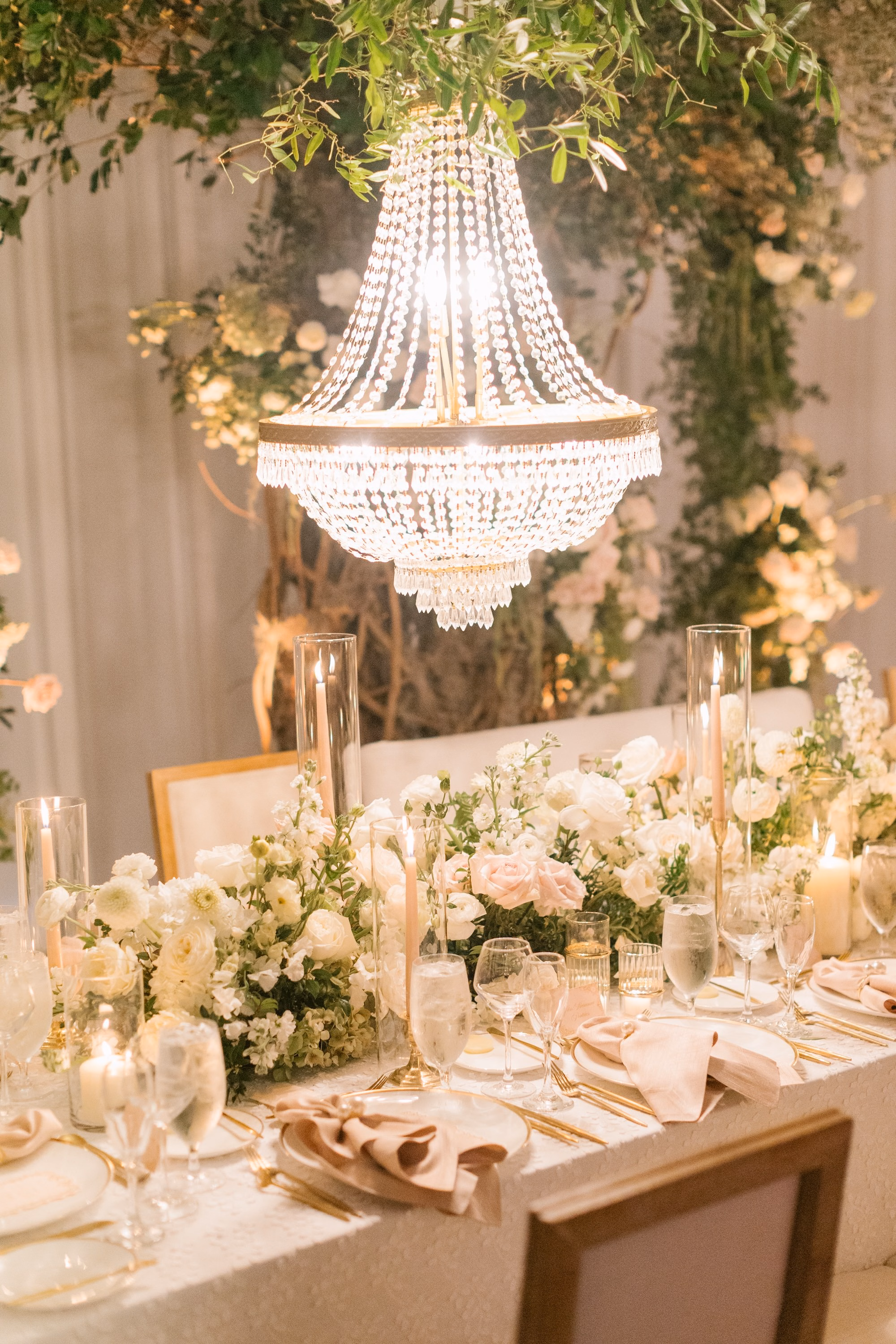 37Luxurious Romantic Garden Ballroom Wedding Inspiration - Luxurious Garden-Inspired Naples Wedding | Hyatt Regency Coconut Point Wedding Reception Long Feasting Table Under Crystal Chandelier | Greenery Tree Installation and Blush Draping Decor Inspiration | White and Blush Floral Tablescape Ideas | Bonita Springs Venue Hyatt Regency Coconut Point | Planner Parties A’ La Carte