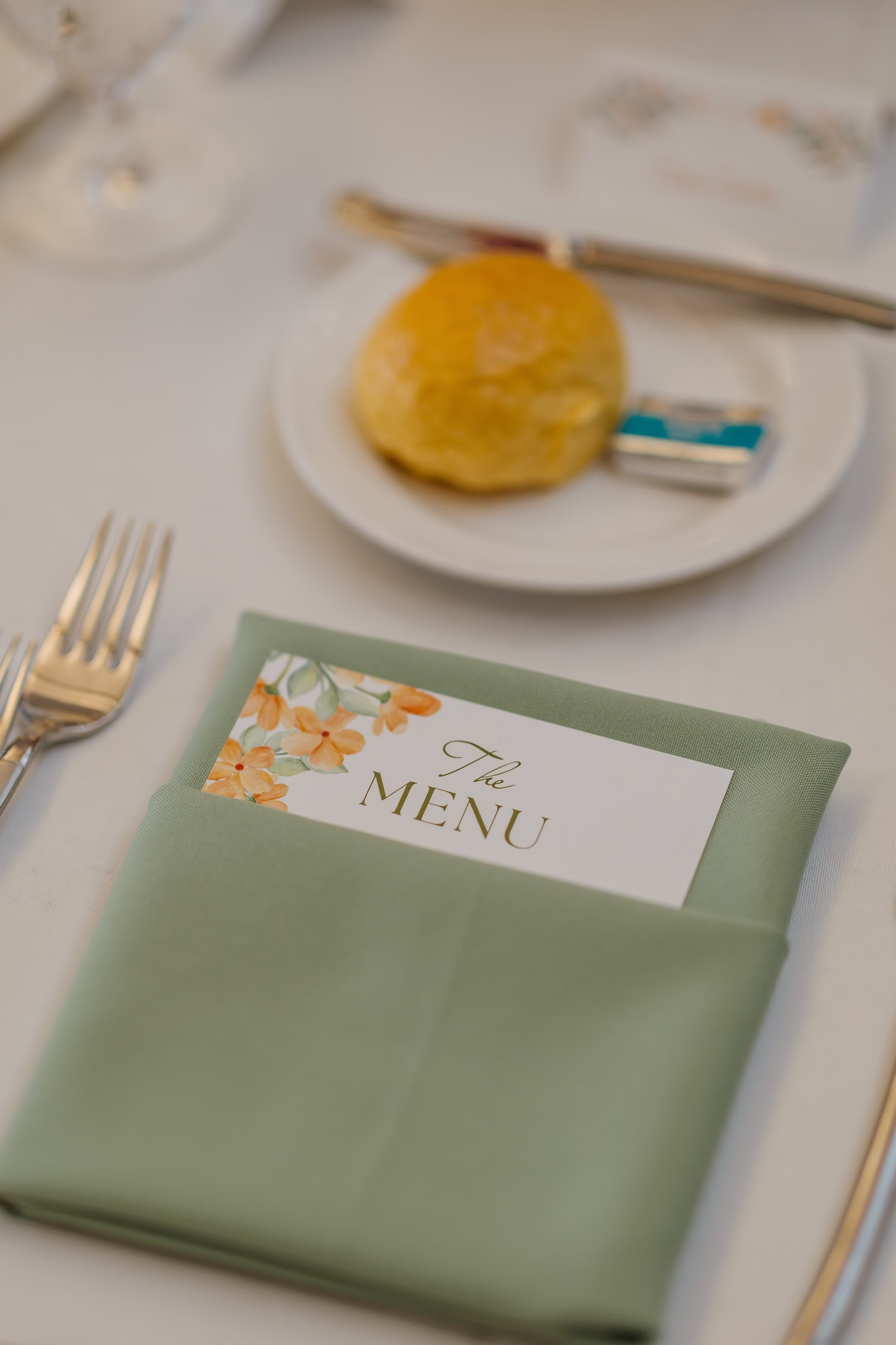 Floral Wedding Menu Card Tucked in Sage Green Napkin with Dinner Roll Place Setting Ideas | St. Pete Planner Coastal Coordinating | Olympia Catering & Events