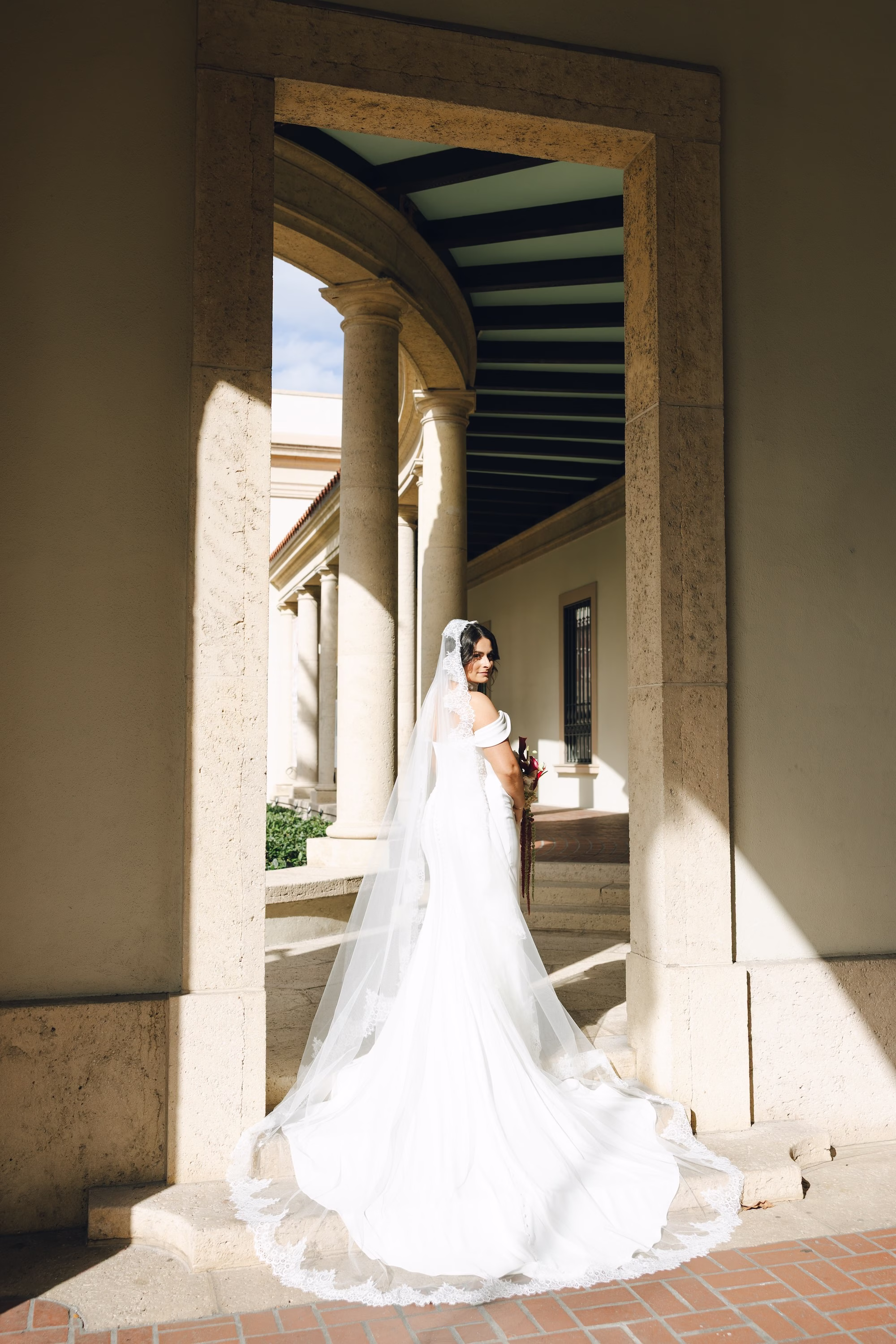 6Burgundy Vintage Romance Wedding Ideas - Vintage Romance Pink and Burgundy Downtown St. Pete Wedding | NOVA 535 Bride in Off-the-Shoulder White Wedding Dress and Cathedral Veil Framed by Stone Archway
