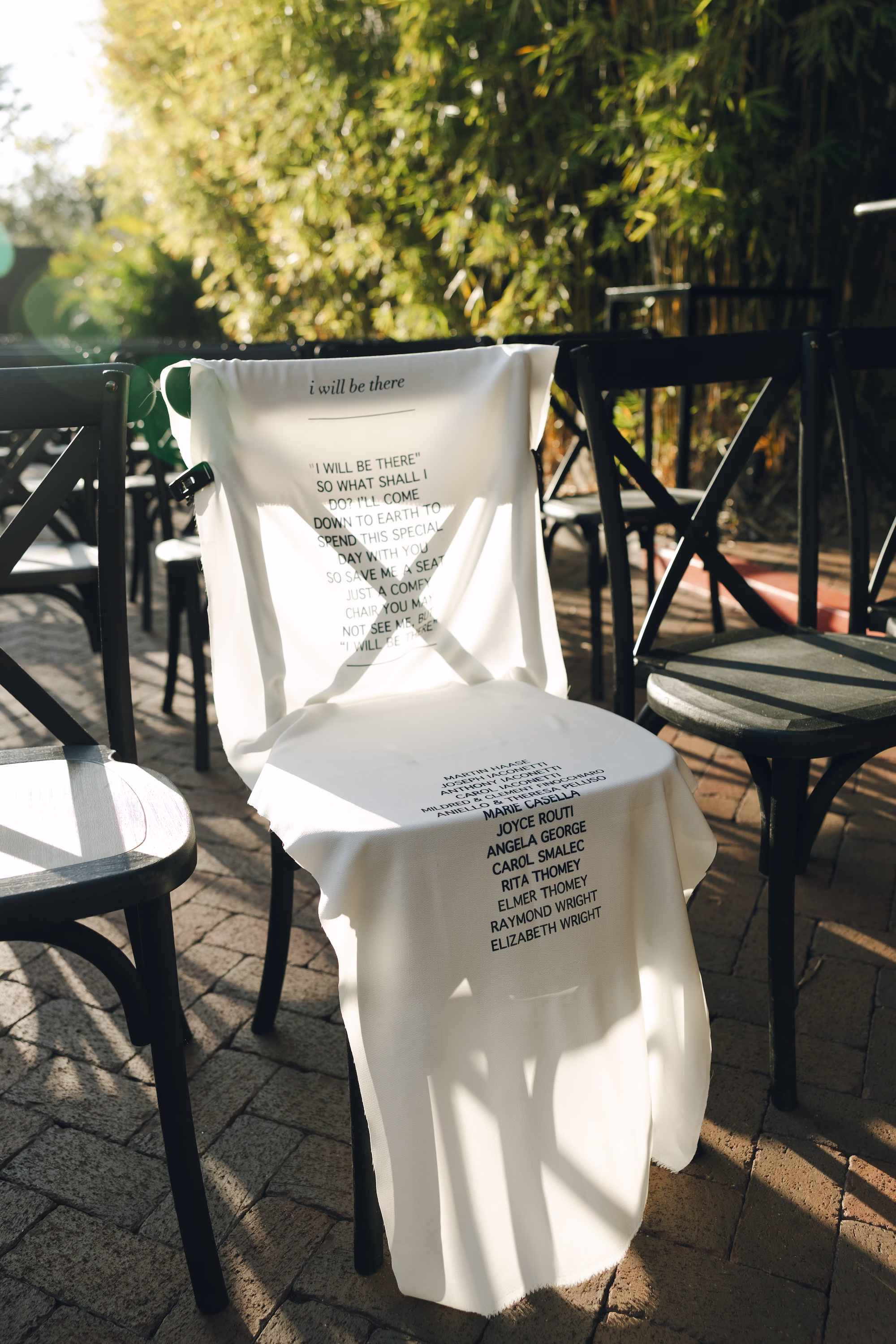 9Burgundy Vintage Romance Wedding Ideas - Vintage Romance Pink and Burgundy Downtown St. Pete Wedding | NOVA 535 Memorial Chair Draped with Printed Fabric Listing Loved Ones Names at Wedding Ceremony Ideas